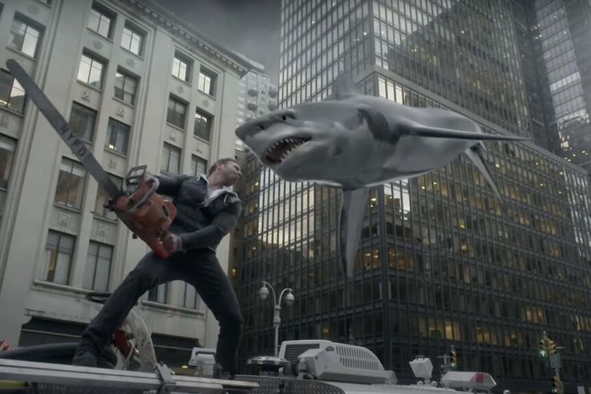Ian Ziering as Fin Shepard with a chainsaw attacks a flying shark.