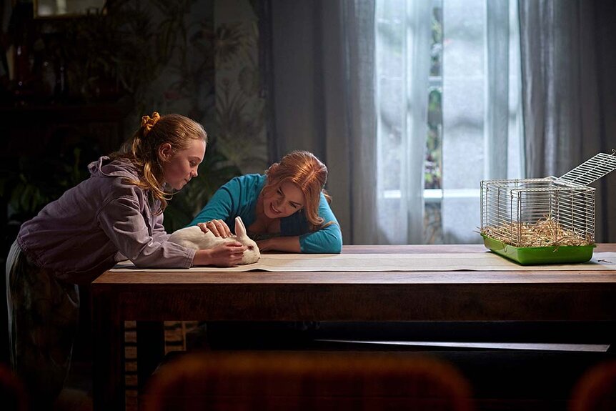 Emma (Ariel Donoghue) and Mary (Isla Fisher) work at a table in Wolf Like Me Season 2