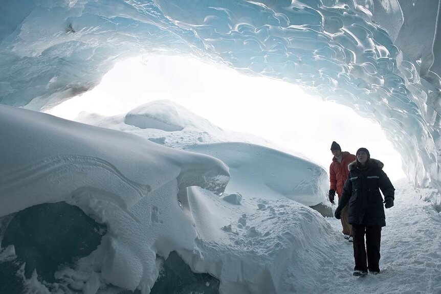 Researchers walk through a snowy alcove in The Thing (2011).