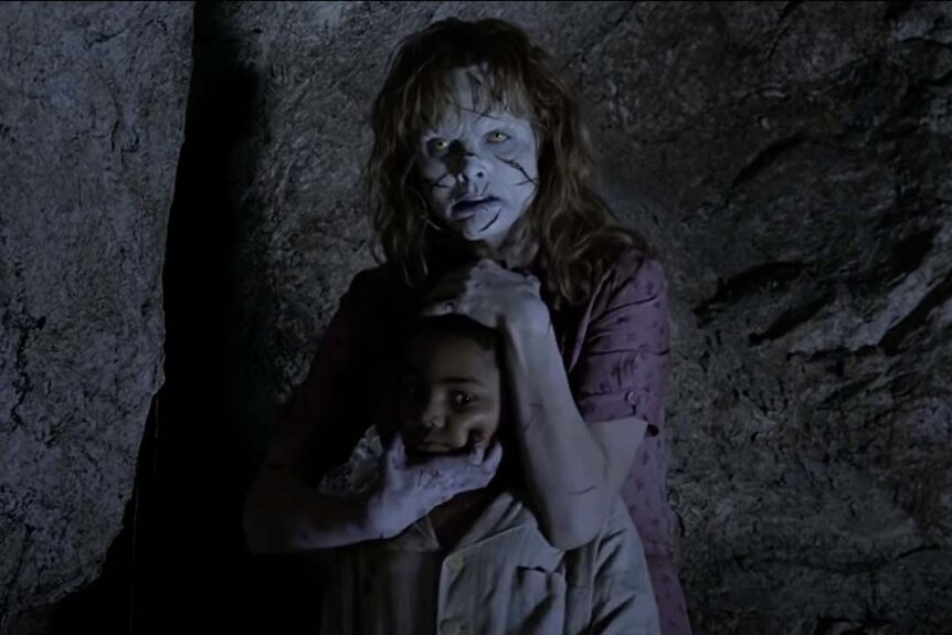 A scratched up Sarah (Izabella Scorupco) holds Joseph (Remy Sweeney) in her arms in Exorcist: The Beginning (2004).