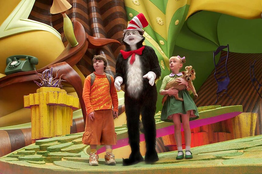 The Cat in the Hat (Mike Myers) (center), Conrad (Spencer Breslin), and Sally Walden (Dakota Fanning) look around a wacky warped world in The Cat in the Hat (2003).
