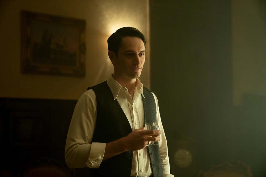 Colin Woodell as Winston holds a glass in The Continental: From the World of John Wick Night 1.