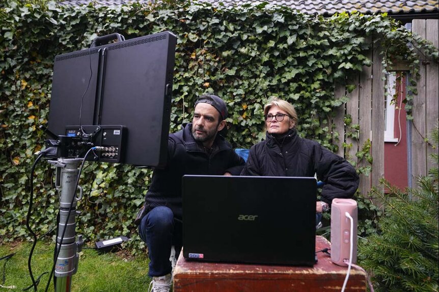 Sandy Carpenter and a crew member look at a monitor behind the scenes of John Carpenter's Suburban Screams 106