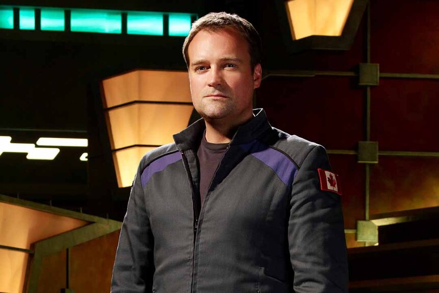 Dr. Rodney McKay (David Hewlett) poses in front of a light structure for Stargate Atlantis Season 5.