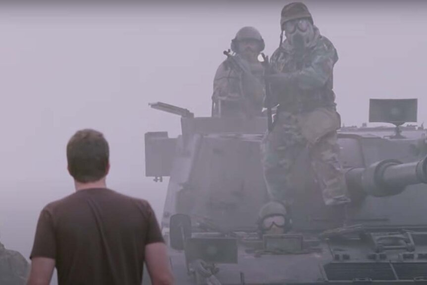 David Drayton (Thomas Jane) watches as soldiers on a tank arrive in The Mist (2007).