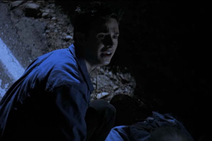 Ray Bronson (Freddie Prinze Jr.) is stressed as he examines a body in I Know What You Did Last Summer (1997).