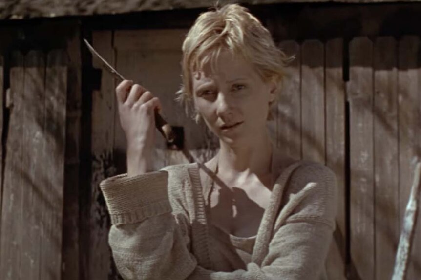 Missy Egan (Anne Heche) holds a knife in front of a shed in I Know What You Did Last Summer (1997).