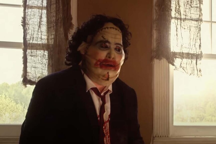 Leatherface (Gunnar Hansen) wears a suit and a frightening leather mask inside a house Texas Chainsaw 3D (2013).