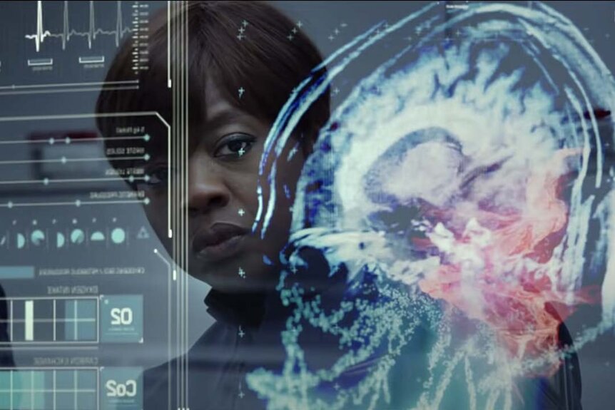 Major Gwen Anderson (Viola Davis) peers at a brain scan on a transparent screened board in Enders Game (2013).