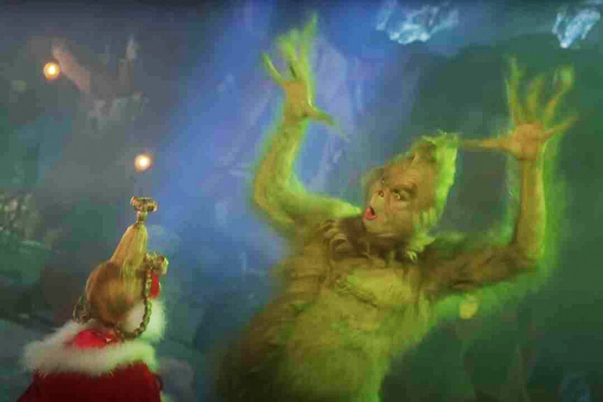 Cindy Lou Who (Taylor Momsen) watches The Grinch (Jim Carrey) raise his arms in How The Grinch Stole Christmas (2000).