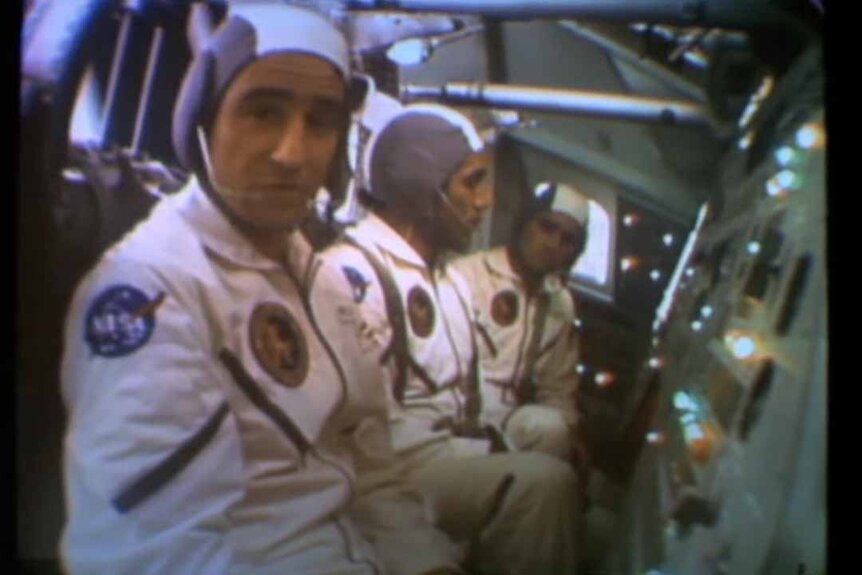 Astronauts sit in a row in uniform in Capricorn One (1977).