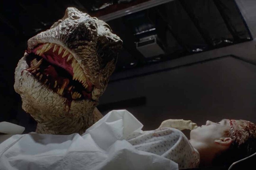A T-Rex bares its teeth over a boy with a head laceration in Tammy and the T-Rex (1994).