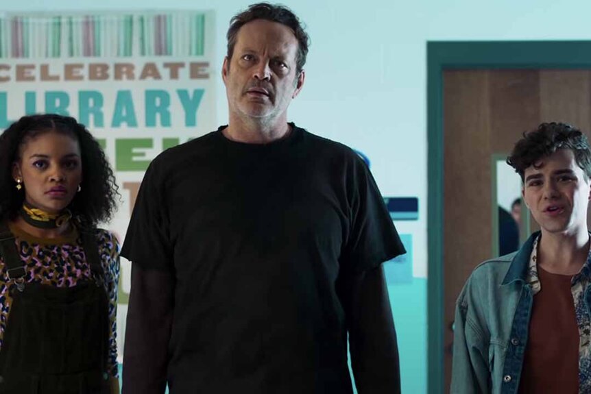 Nyla (Celeste O’Connor), The Butcher (Vince Vaughn), and Joshua (Misha Osherovich) stand in a school hallway in Freaky (2020).