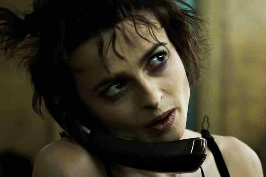 Marla Singer (Helena Bonham Carter) talks on a black phone between her head and shoulders in Fight Club (1999)