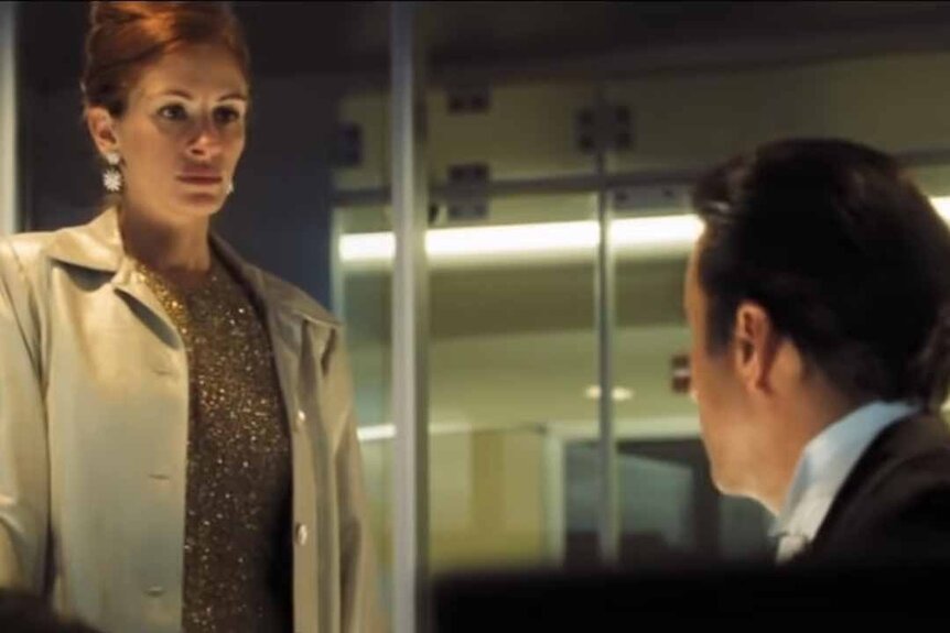 Tess (Julia Roberts) wears a beige jacket while talking to Terry (Andy Garcia) in Ocean's Eleven (2001).