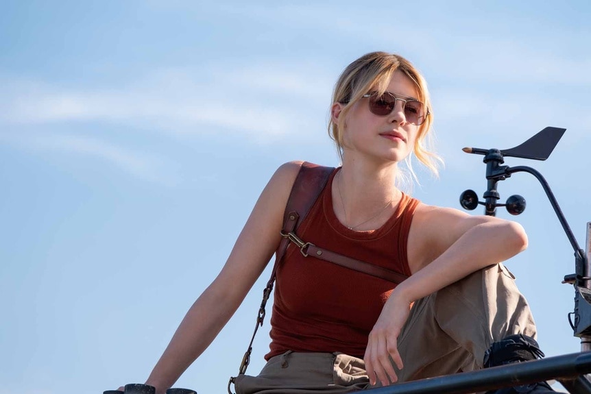 Kate (Daisy Edgar-Jones) wears a red tank top and sunglasses in Twisters (2024).