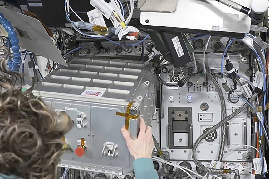An astronaut works with hardware on the International Space Station.