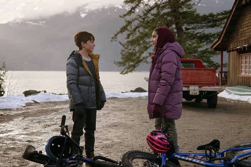 Max Hawthorne and Sahar speak near a lake and cabin in Resident Alien Episode 301.
