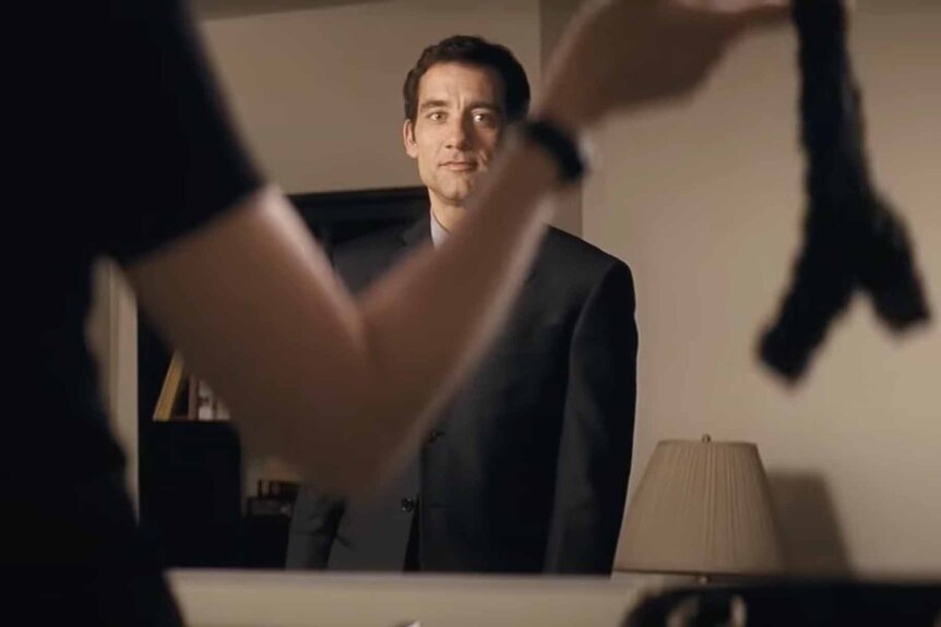 Ray Koval (Clive Owen) looks at a woman holding up a thong in Duplicity (2009).
