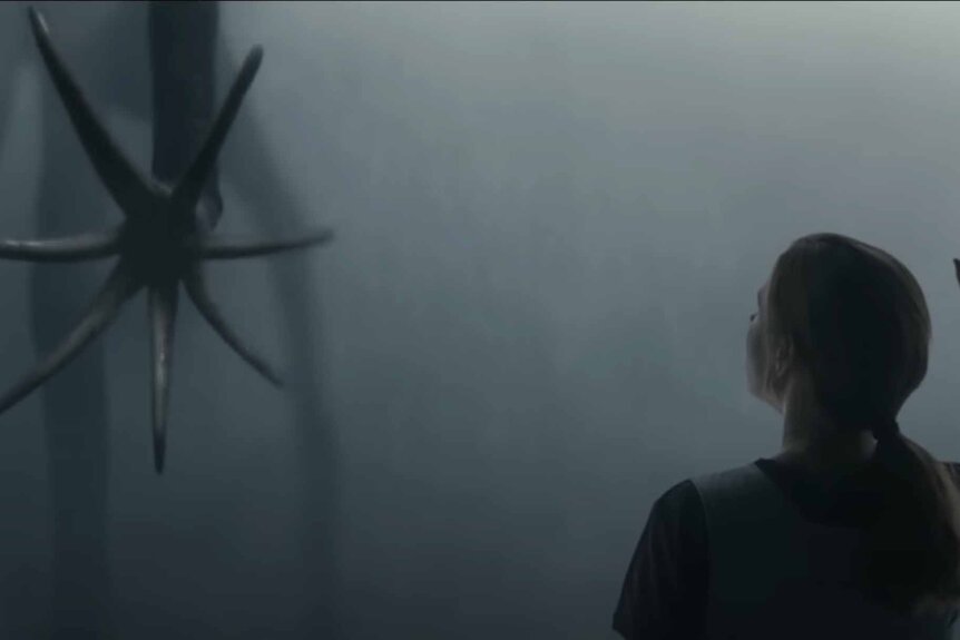 A tentacled alien hand reaches out to a woman in Arrival (2016).