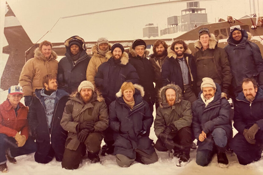 The cast of The Thing (1982) pose outdoors in winter gear.