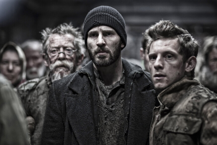 Gilliam (John Hurt),Curtis (Chris Evans), and Edgar (Jamie Bell) appear dirty and disheveled in Snowpiercer (2013).