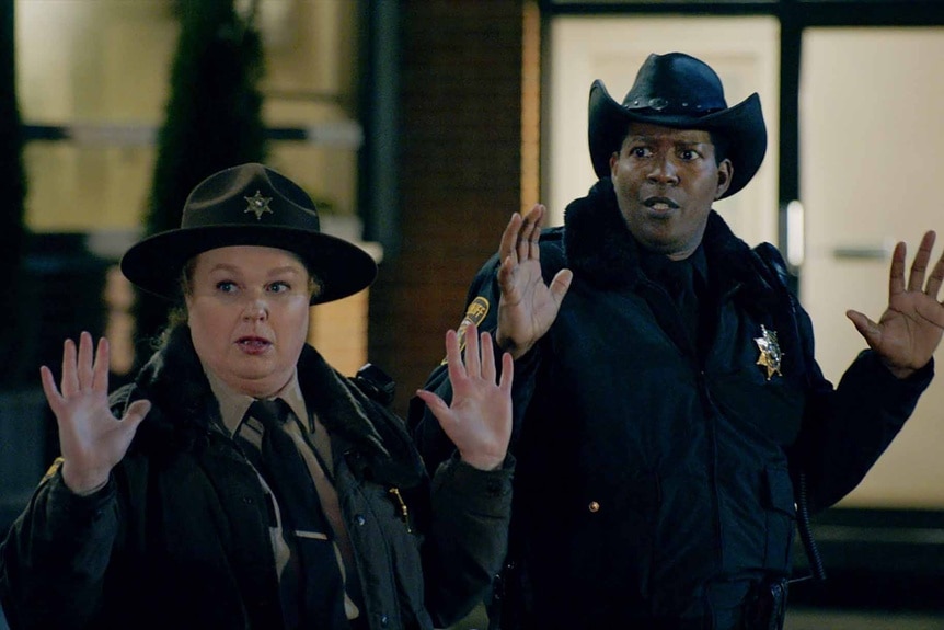 Deputy Liv Baker and Sheriff Mike Thompson hold their hands up on Resident Alien Season 3 Episode 7.