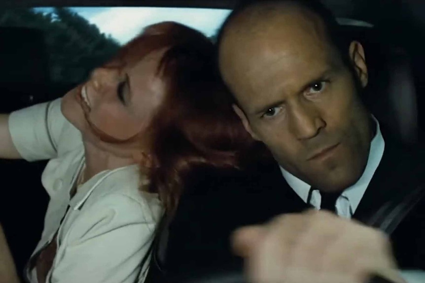 Valentina (Natalya Rudakova) and Frank Martin (Jason Statham) are thrown around in a car in Transporter 3 (2008).