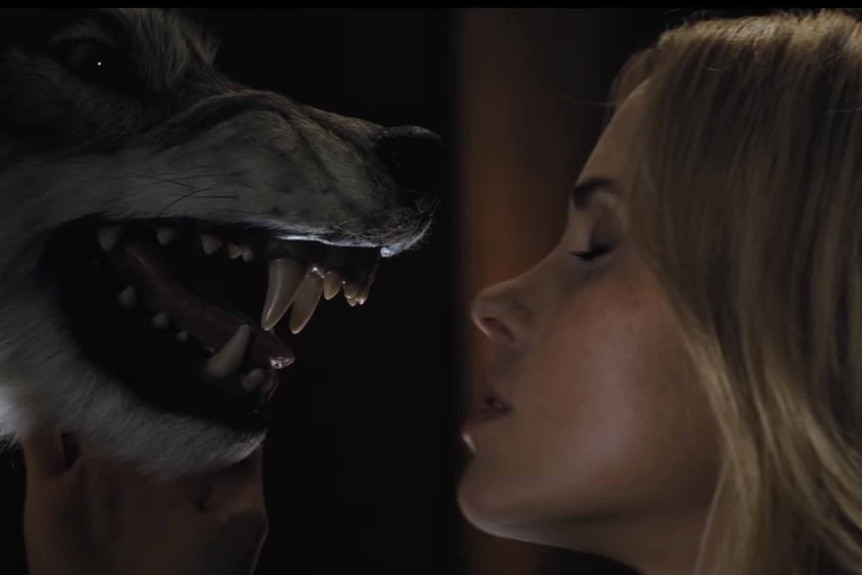 Jules Louden (Anna Hutchinson) kisses a taxidermy wolf in Cabin in the Woods (2012).