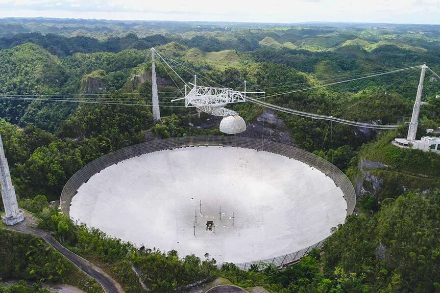 The enormous Arecibo radio telescope in Puerto Rico, in a photo taken in 2019 before it was damaged by broken cables. The NSF plans on decommissioning it soon. Credit: UCF