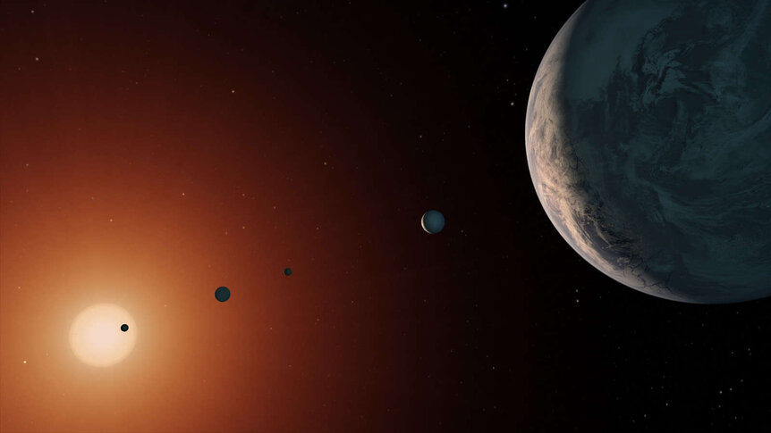 Artwork showing the TRAPPIST-1 planetary system, seven Earth-sized planets orbiting a cool red dwarf. Credit: NASA/JPL-Caltech