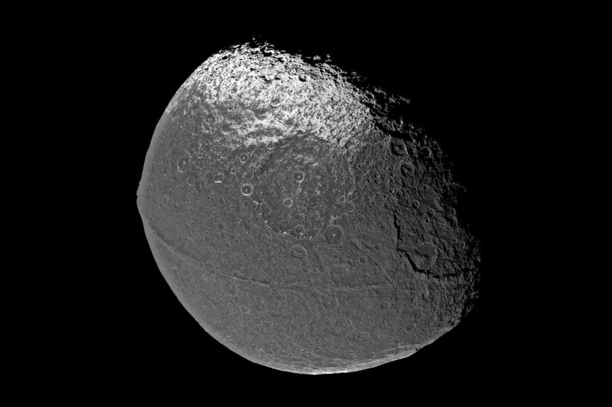 Iapetus is a moon of Saturn, and has a very weird ridge of mountains going all the way around its equator. Credit: Cassini Imaging Team, SSI, JPL, ESA, NASA