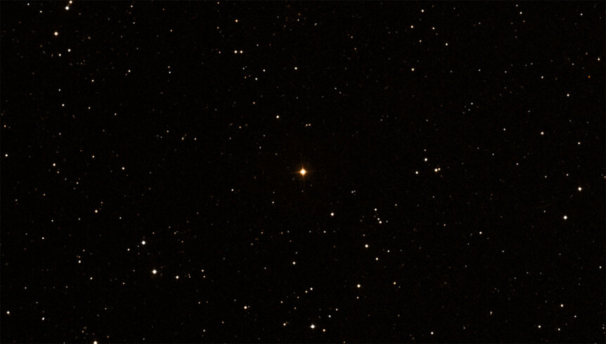 The red giant star T Ursae Minoris (center). Note the color. Credit: DSS