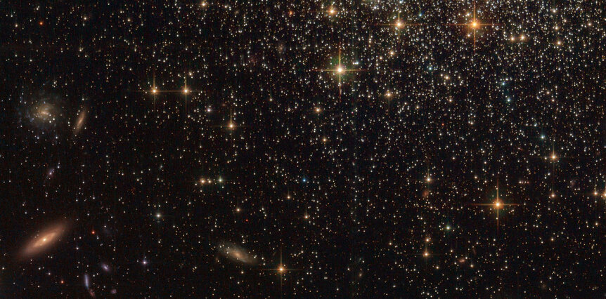 Background galaxies litter the sky far, far behind the globular cluster NGC 1466. Credit: ESA/Hubble & NASA