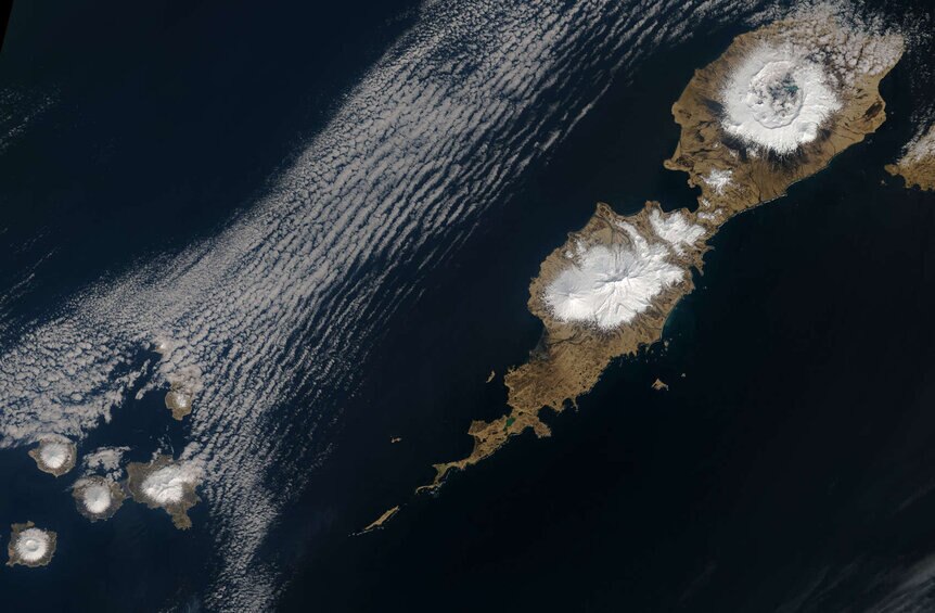 A rare clear day in 2014 over Umnak island in the western Aleutian islands shows the massive Okmok caldera (upper right), which is over 9 km wide. Credit: NASA Earth Observatory images by Joshua Stevens, using Landsat data from the U.S. Geological Survey