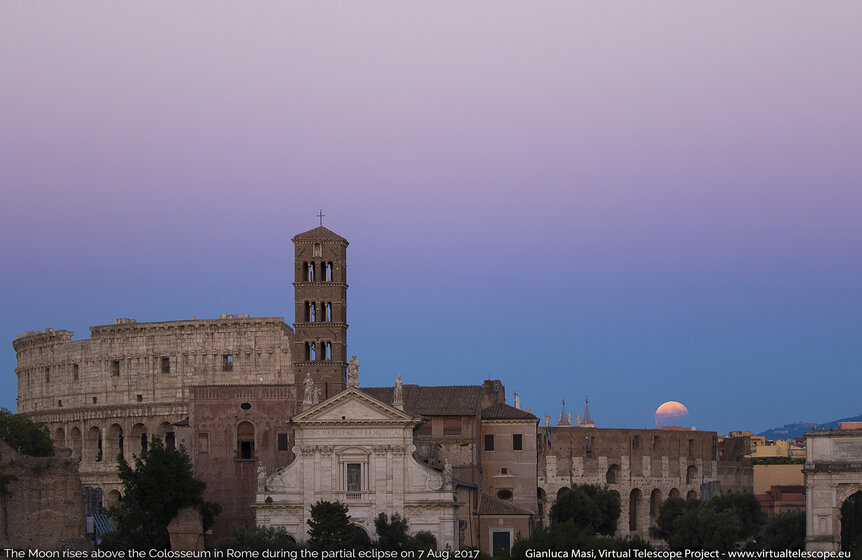 The partially eclipsed Moon rises over the Roman Colosseum.