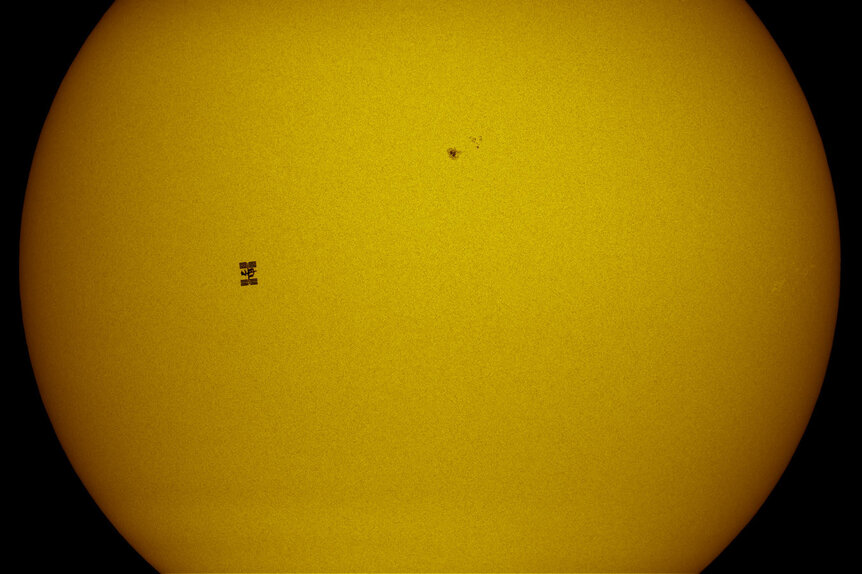 The space station transiting the Sun. The sunspot to the upper right is about the same size as the Earth ... but a lot farther away than ISS. Credit: Thierry Legault