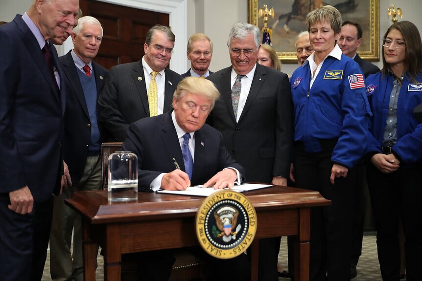 On December 11, 2017, President Trump signed the National Space Policy directive. Astronaut Harrison Schmitt presented him with an Apollo figurine as astronaut Peggy Whitson (right) looks on. Credit: Chip Somodevilla/Getty Images