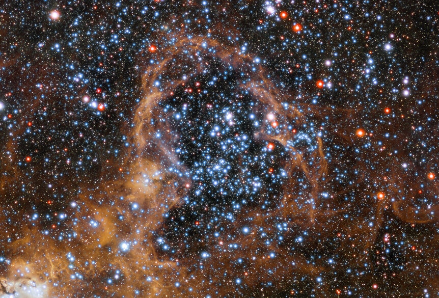 Detail of the Tarantula Nebula of a cluster of stars plowing up gas around them into a thin shell. Credit: ESO