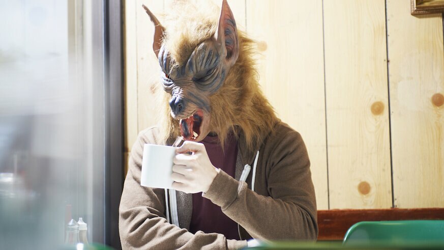 Werewolf with mug in cafe