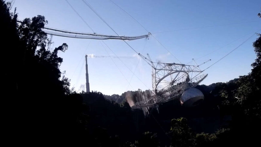 A still from the video of the Arecibo radio telescope collapse shows the massive 900-ton platform swinging down after supporting cables snapped. Credit: Courtesy of the Arecibo Observatory, a U.S. National Science Foundation facility