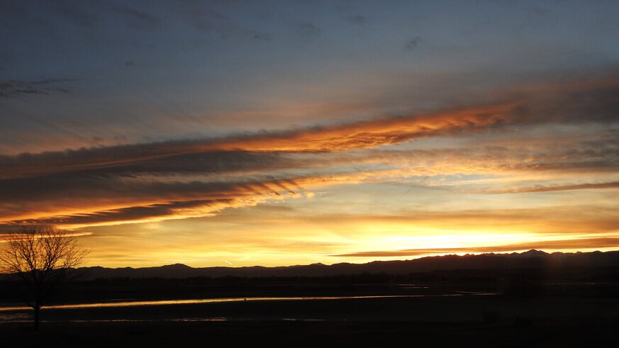 A wide view of a Colorado sunset shows fluctus clouds, crepuscular rays, and magnificent colors. Credit: Phil Plait