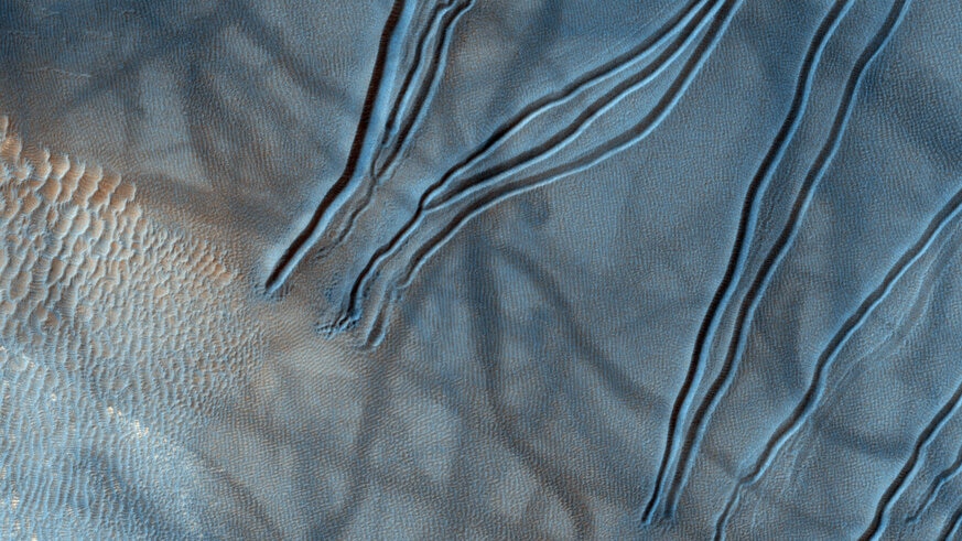 A color close-up image of gullies on Mars shows dimpling near their source, implying subsurface materials sublimating in the warmer seasonal weather. Credit: NASA/JPL/University of Arizona