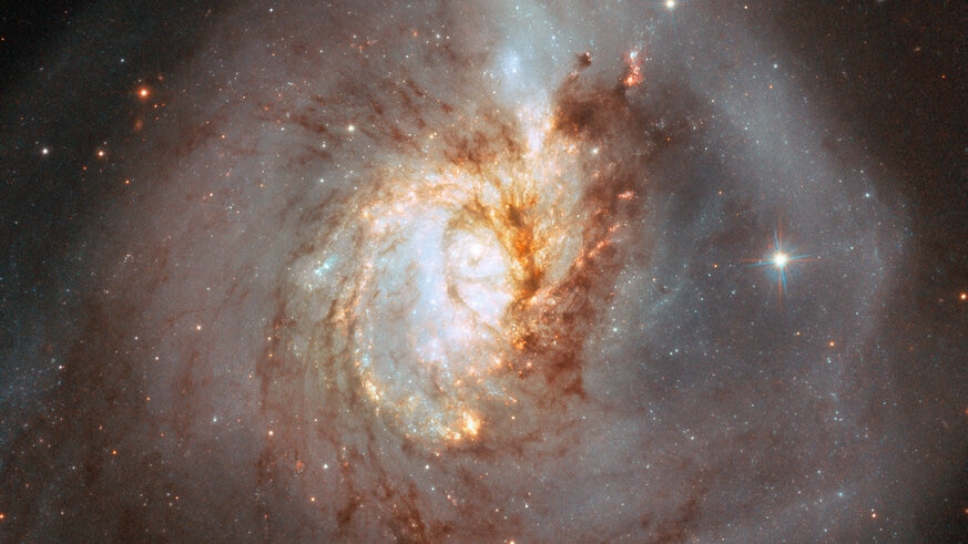 A closer look at the center of NGC 3256 reveals the chaos there, struggling to recover order. Dark dust clouds and bright stars may yet retain their overall spiral distribution.  Credit: ESA/Hubble, NASA