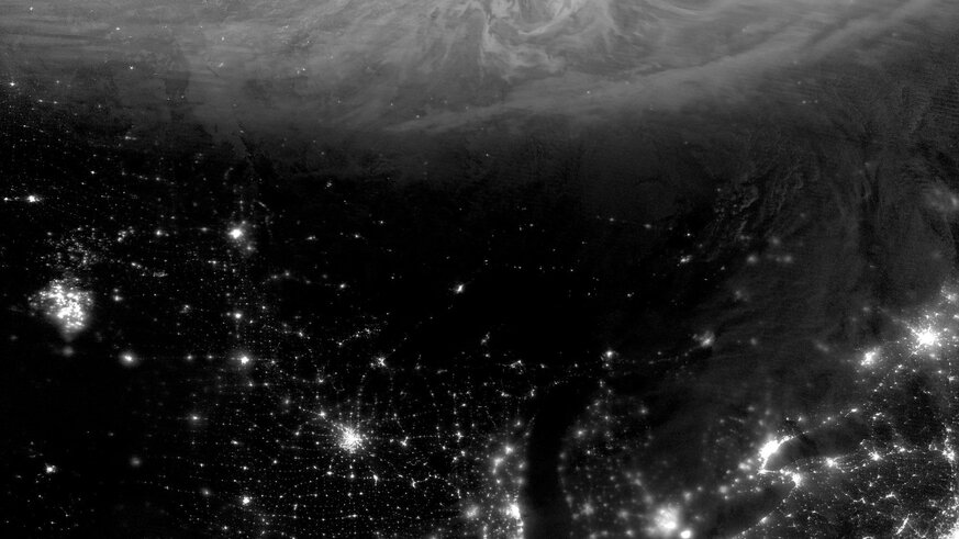 The aurora swirls in northern Canada while the lights from US cities illuminate the night… as well as something else ominously glowing in the American Upper Midwest.