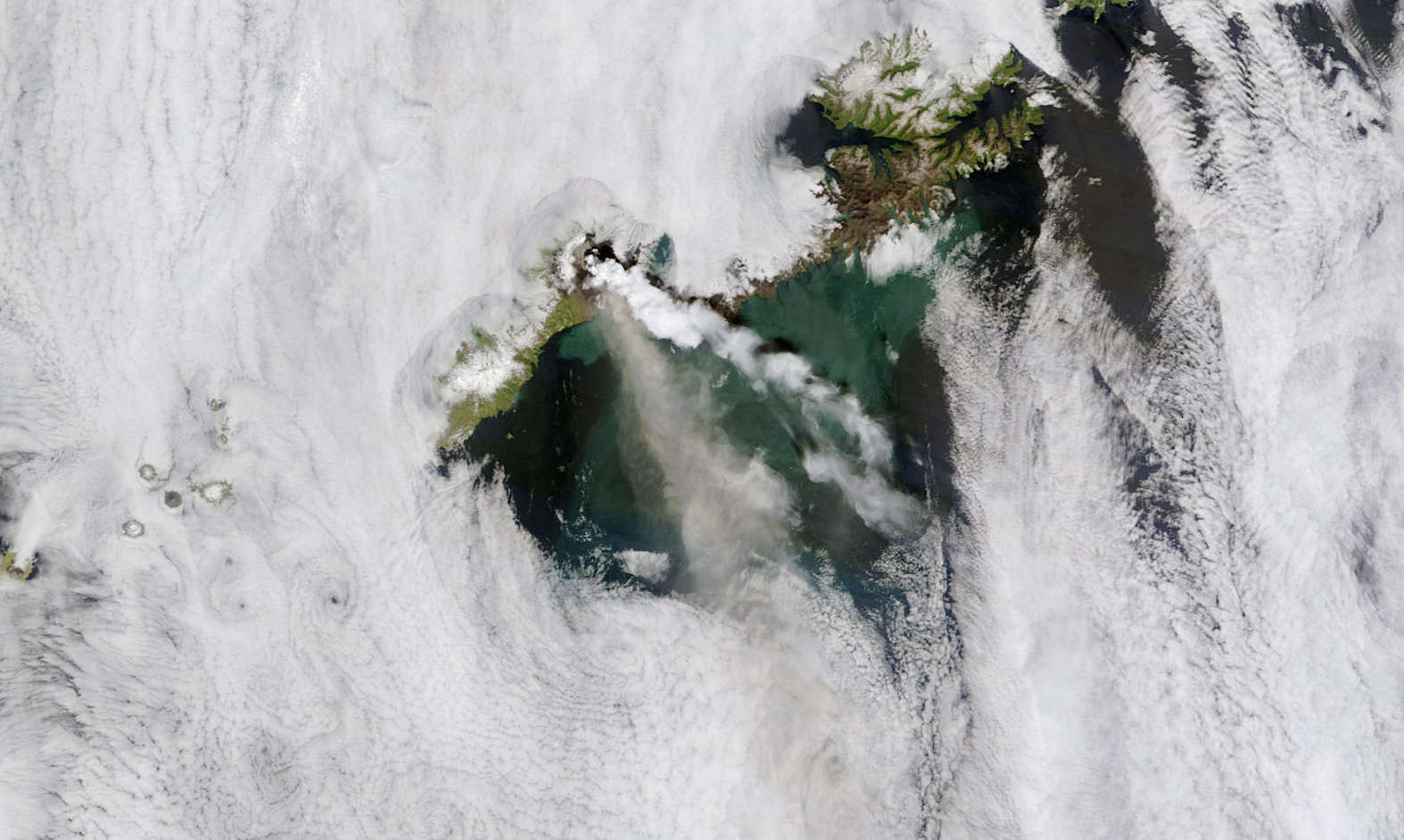 The 2008 eruption of Okmok seen from space by NASA’s Terra satellite. The steam cloud (white) is well over 100 km long, and an ash/gas cloud can be seen below it. Credit: NASA image courtesy MODIS Rapid Response team