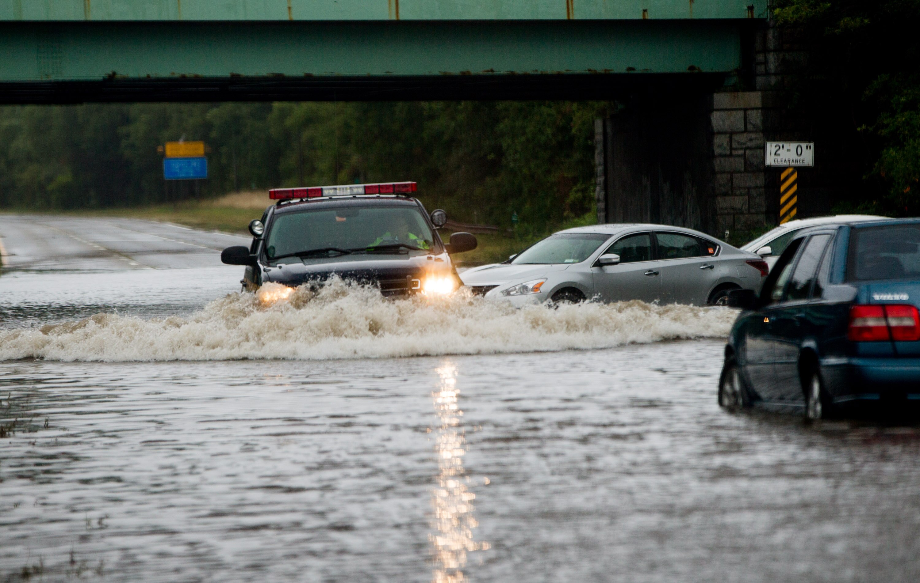 453561078-police-officer-drives-past-flooded-cars-abandoned-on.jpg