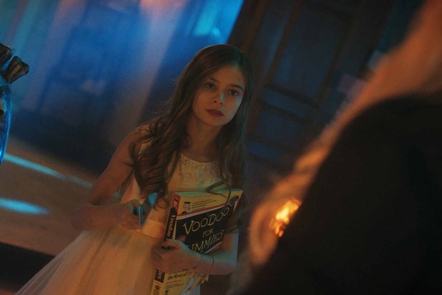 Caroline Cross holds a knife and "Voodoo for Dummies" book on Chucky Episode 308.