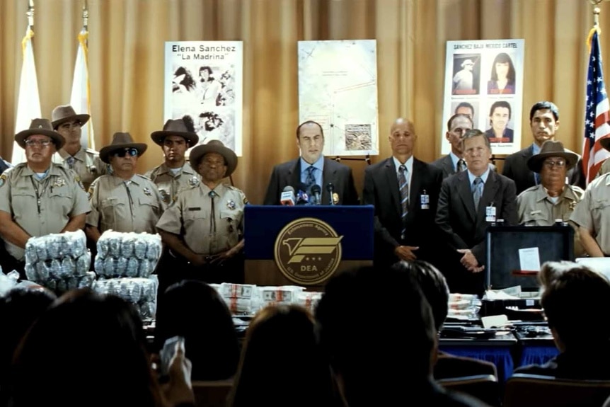 A police press conference appears in Savages (2012).